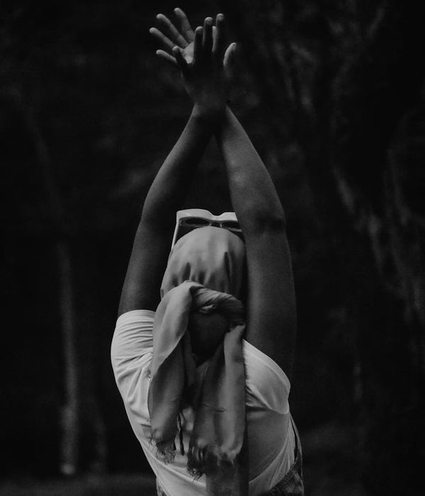 Woman in a calm yoga pose on a dark background with cyan accents.